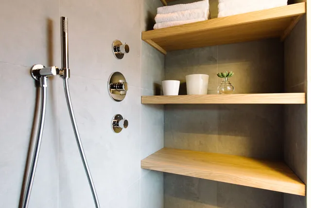 Eikenhouten schappen in een betonlook nis naast de douche